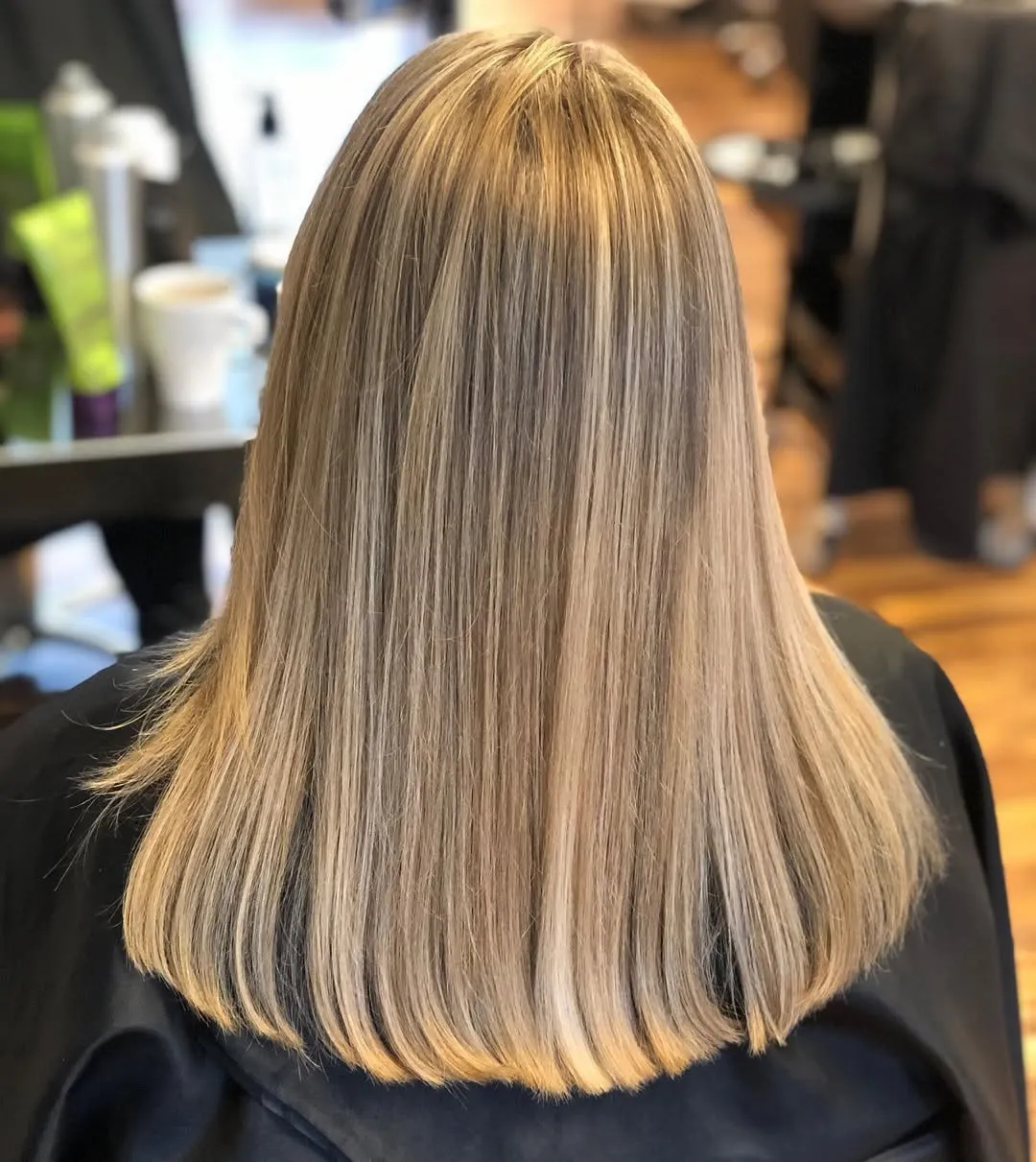 Mellanlångt hår med blonda highlights och rak styling